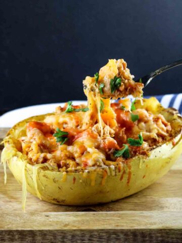 buffalo chicken spaghetti squash with someone pulling up a bite on a fork