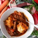 a bowl of guinness beef stew with garlic cheddar dumplings