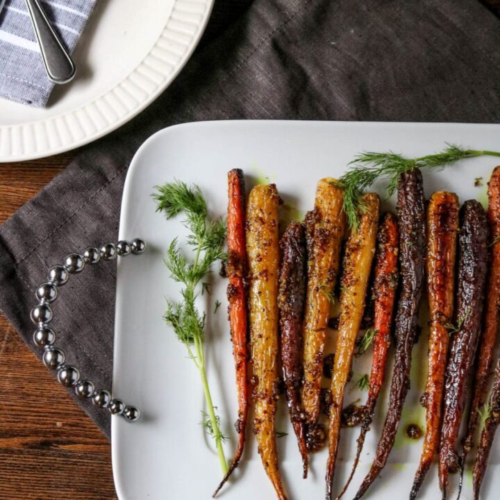 a white platter of maple mustard roasted carrots