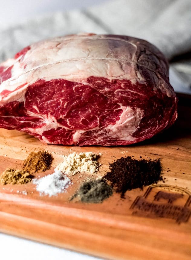 a 4 pound Certified Angus Beef prime rib sitting on a cutting board. The spices for the prime rib are sitting in small piles on the cutting board.