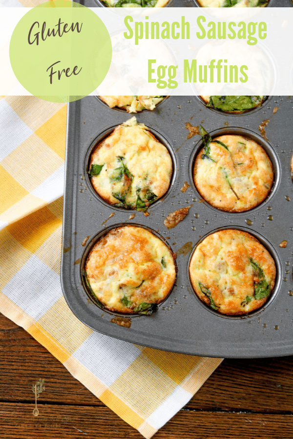 a silver muffin tin with spinach sausage egg muffins