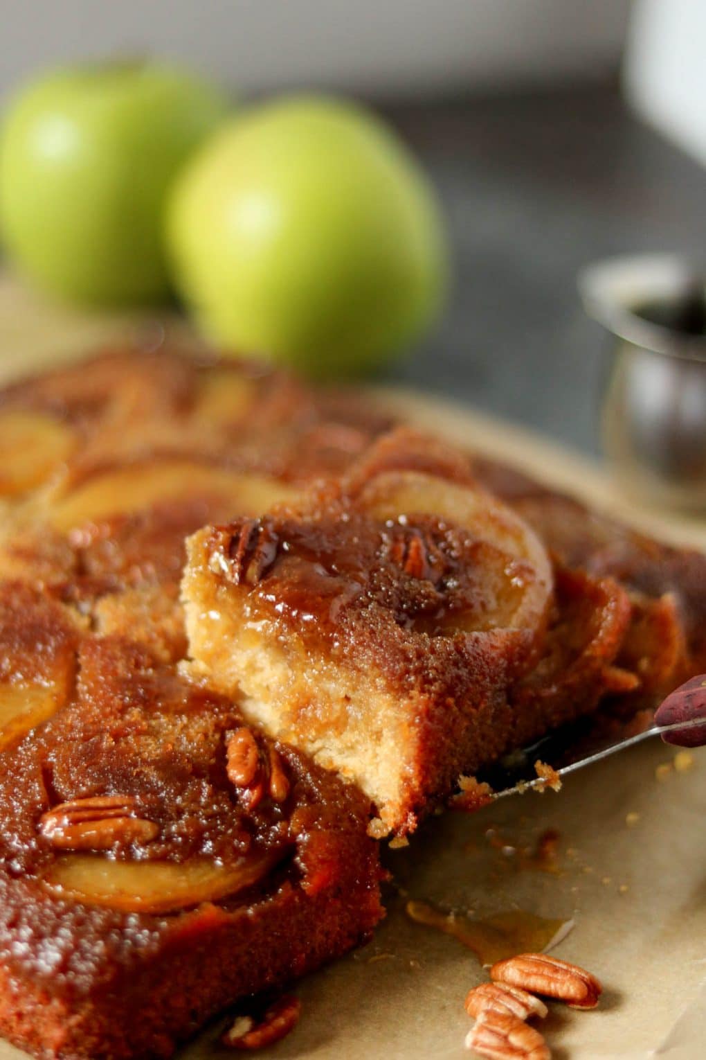 a slice of apple upside down cake being pulled up by a spatula