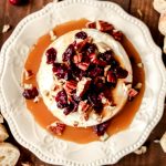 cranberry caramel baked brie on a white plate