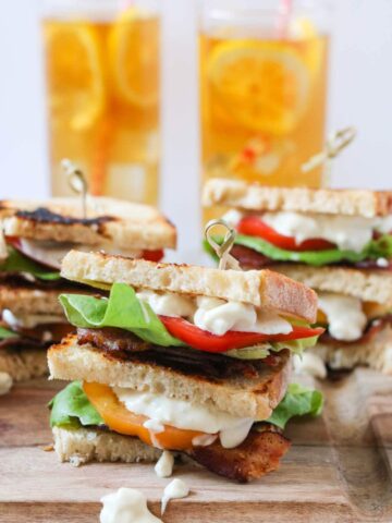 BLT club sandwich with blue cheese mayo and glasses of iced tea in the background