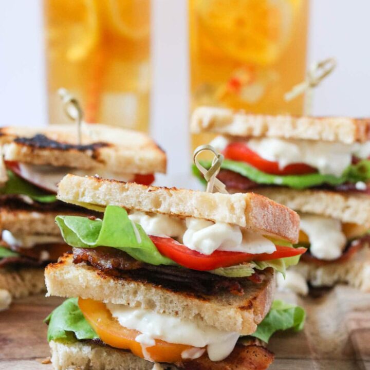 BLT club sandwich with blue cheese mayo and glasses of iced tea in the background