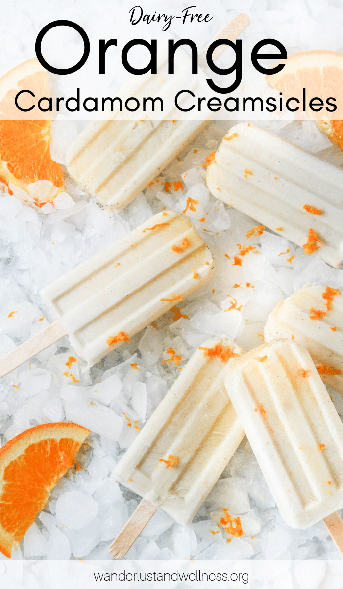 several orange cardamom creamsicles laying on a bed of ice