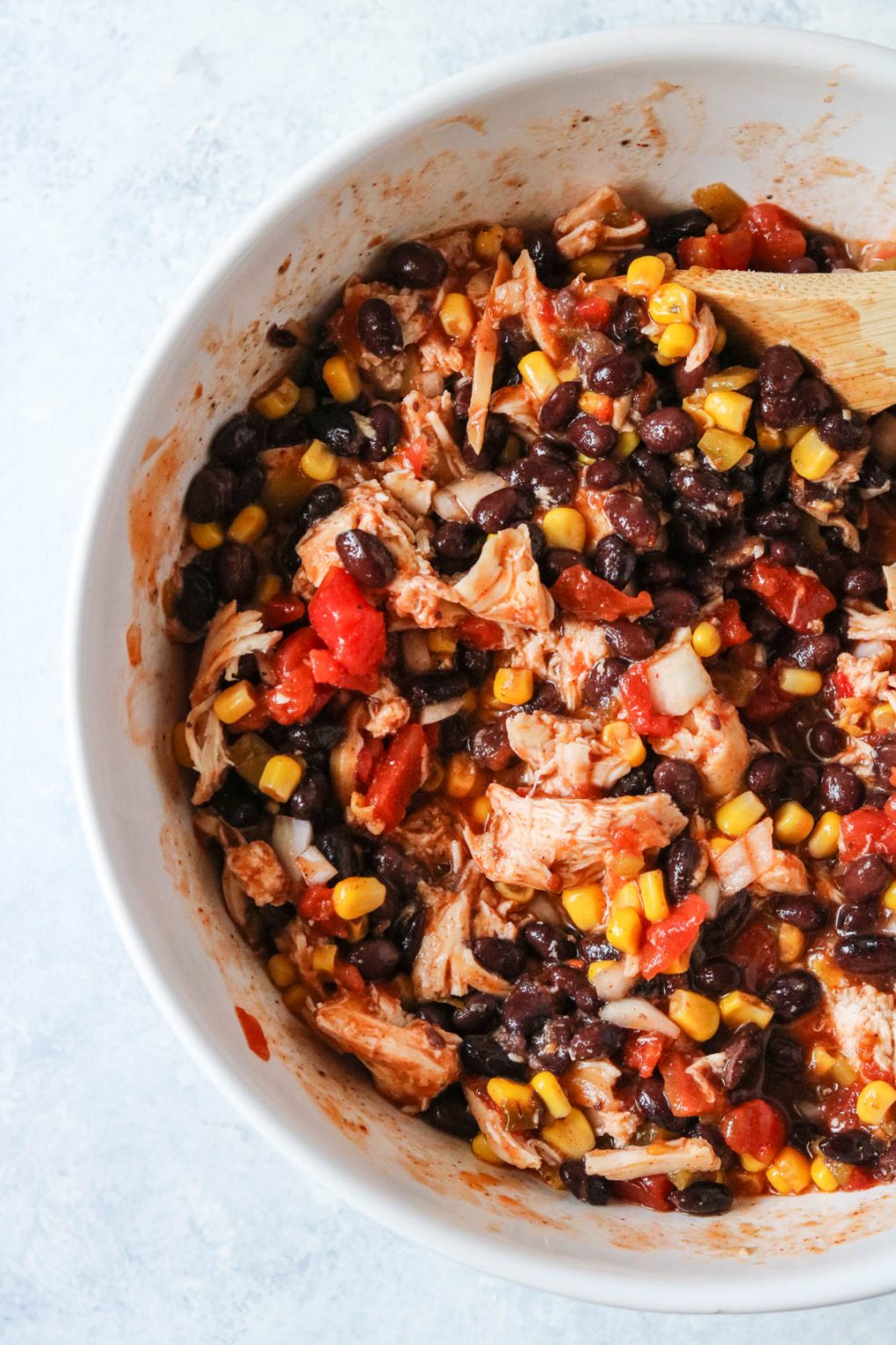 chicken enchilada casserole ingredients mixed together in a bowl