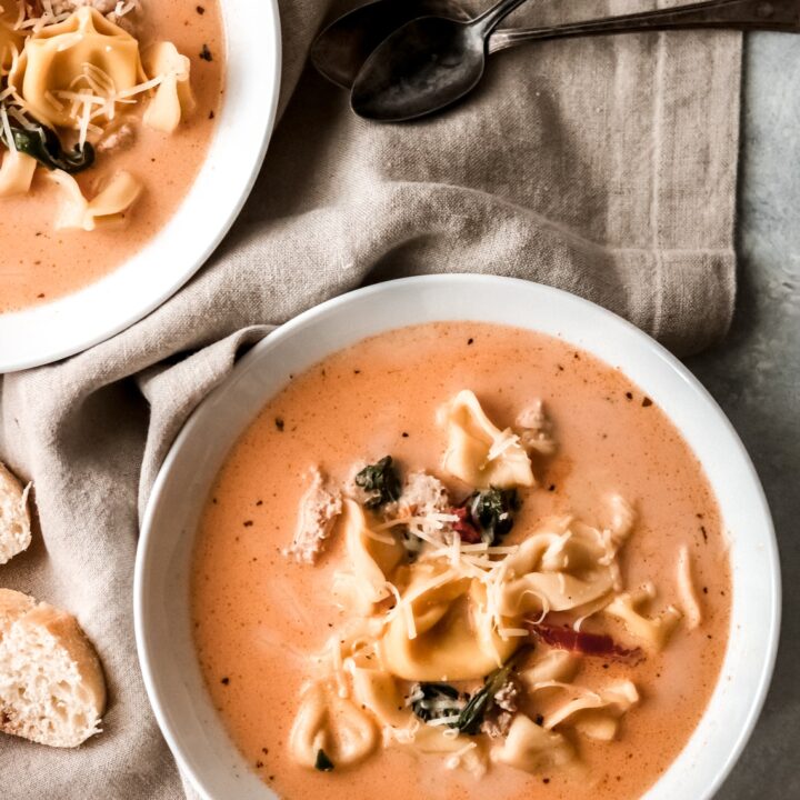 two bowls of creamy tomato tortellini soup