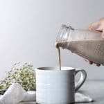 someone pouring the dairy-free cinnamon roll coffee creamer into a cup of coffee
