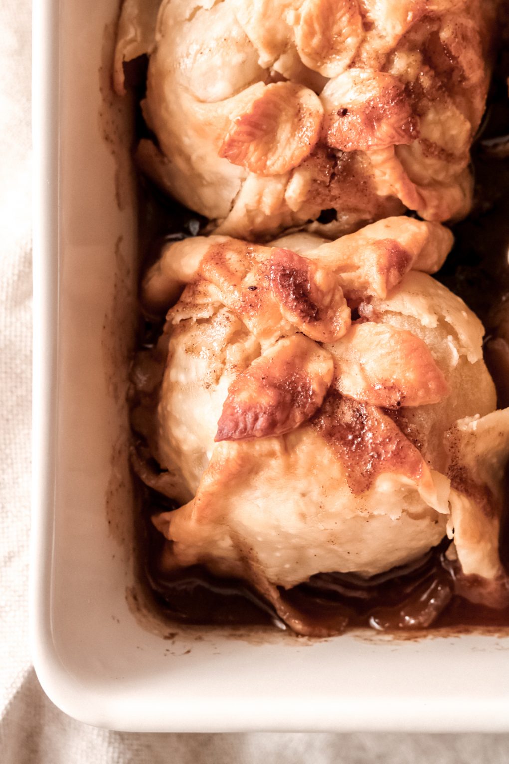 a baking dish with baked apple dumplings
