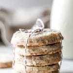 A stack of five London fog shortbread cookies, wrapped with string, and a jug of milk in the background