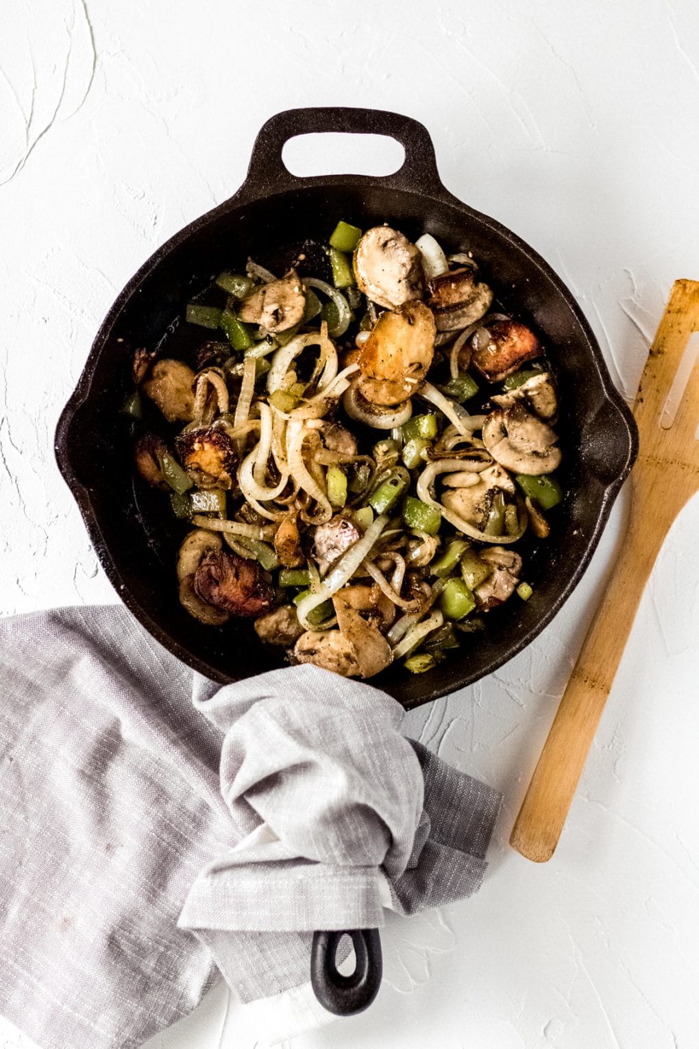 a cast iron skillet with sautéed mushrooms, onions, and green peppers