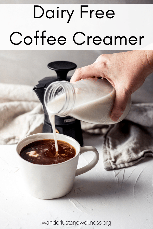 a woman pouring coffee creamer into a cup of coffee