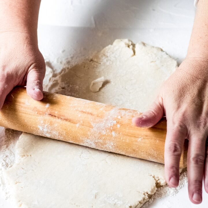 a woman rolling out gluten-free galette dough