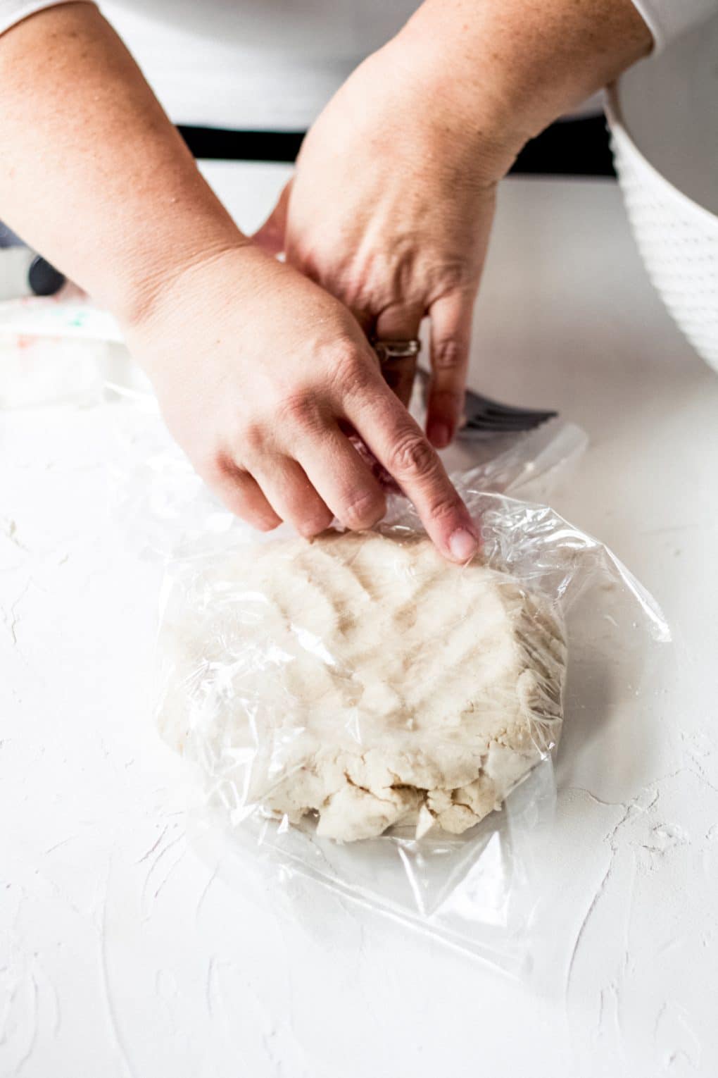 a woman wrapping gluten-free galette dough in plastic wrap