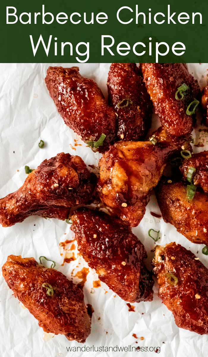 barbecue chicken wings scattered onto a sheet of white parchment paper