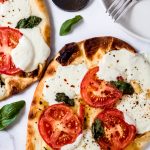 two tomato basil mozzarella flatbread pizzas