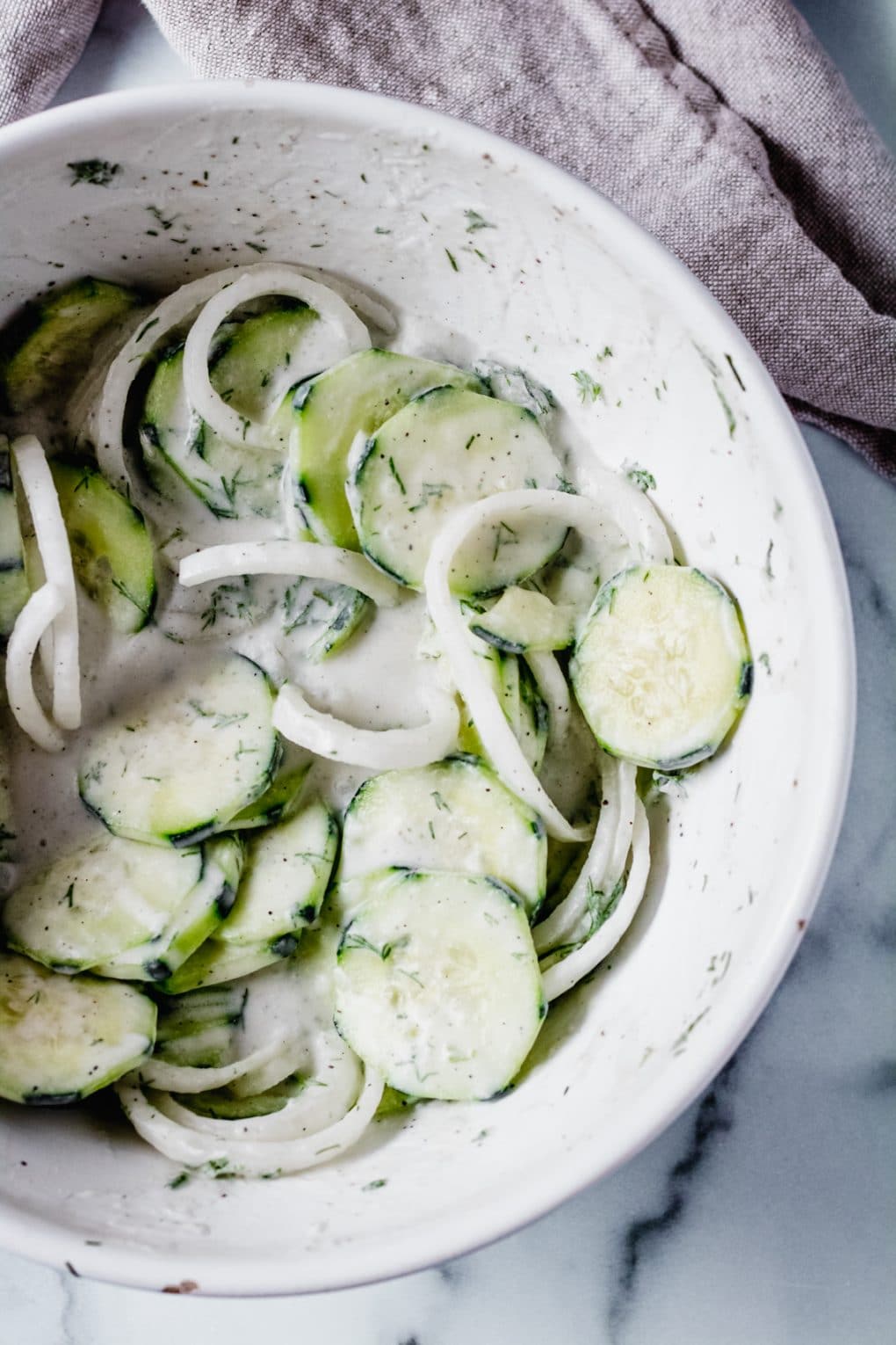 ingredients for creamy cucumber salad in a bowl