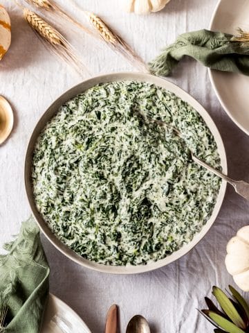 a bowl of creamed spinach on a Thanksgiving tablescene