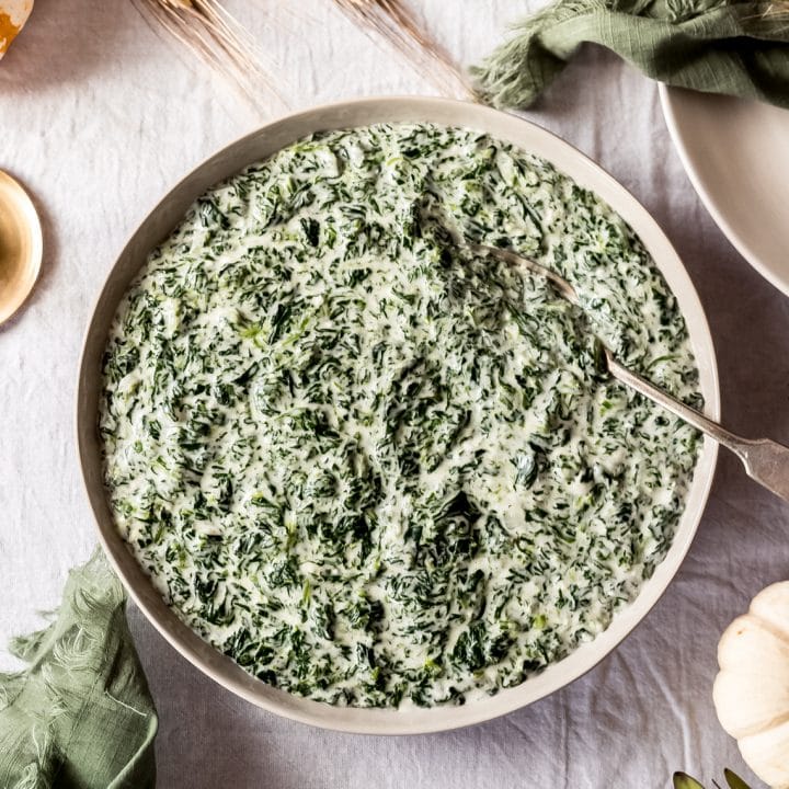 a bowl of creamed spinach on a Thanksgiving tablescene