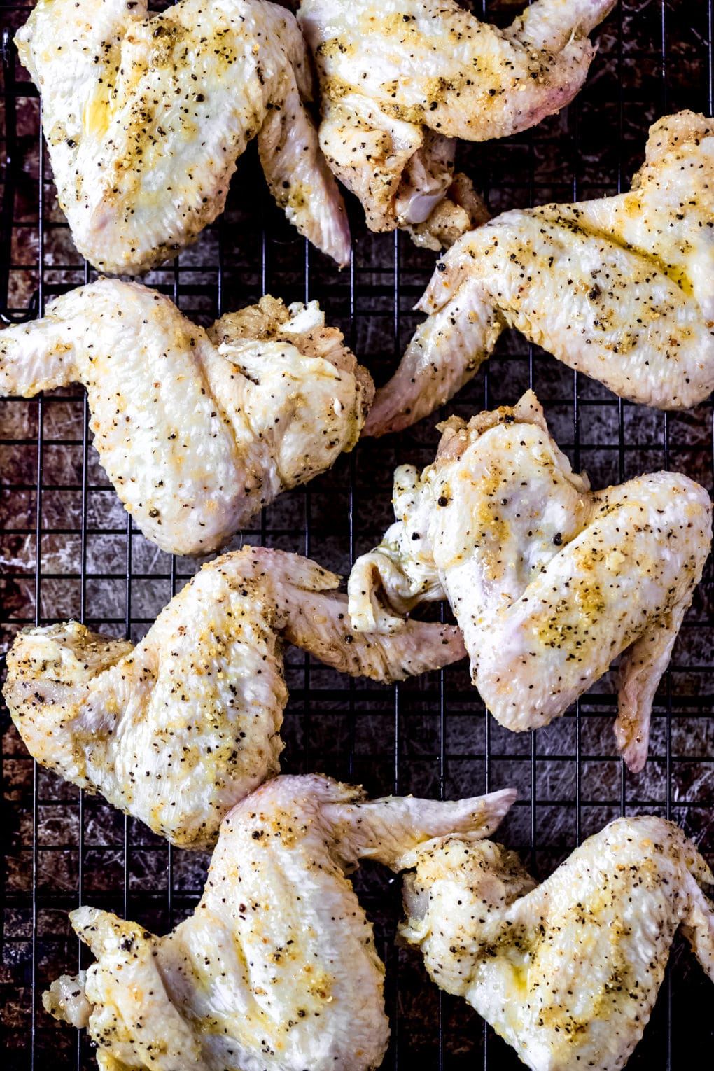 raw lemon pepper chicken wings on a baking sheet