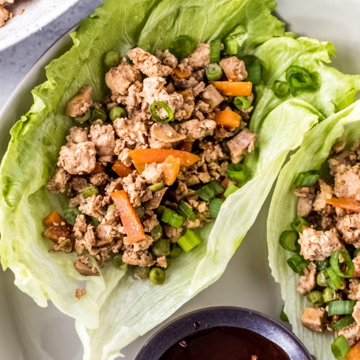 an Asian chicken lettuce wrap on a white plate
