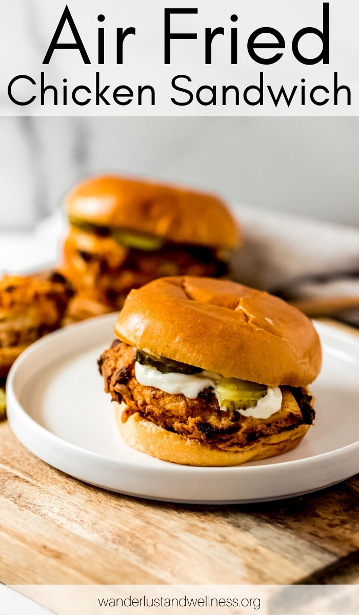 an air fried chicken sandwich on a white plate, there's another sandwich in the background
