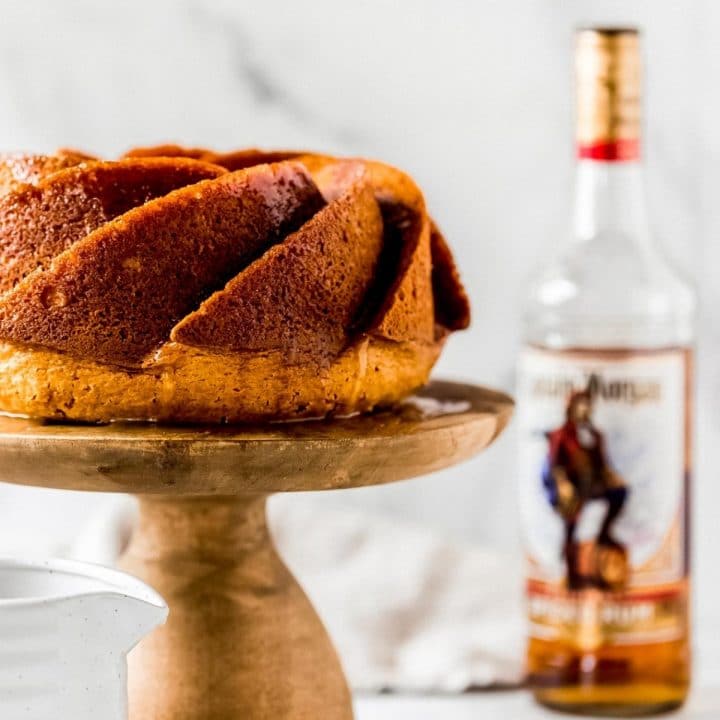 a rum cake on a wooden cake stand