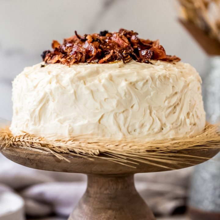 a maple bacon cake on a wooden cake stand