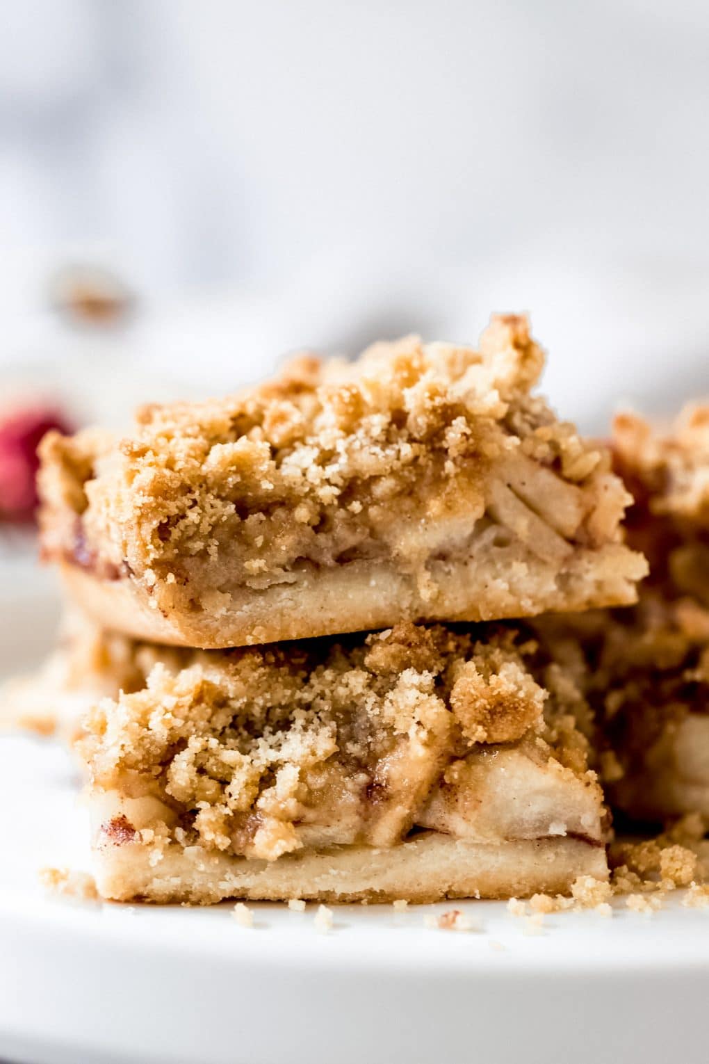 two apple pie shortbread bars stacked on a white plate