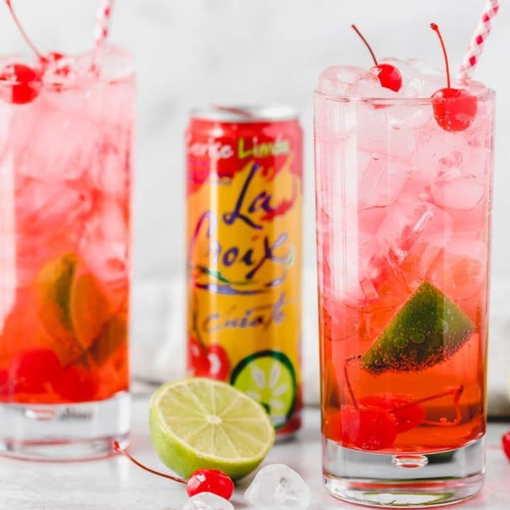 two glasses of cherry lime la croix cocktail with a can of La Croix Cerise Limon