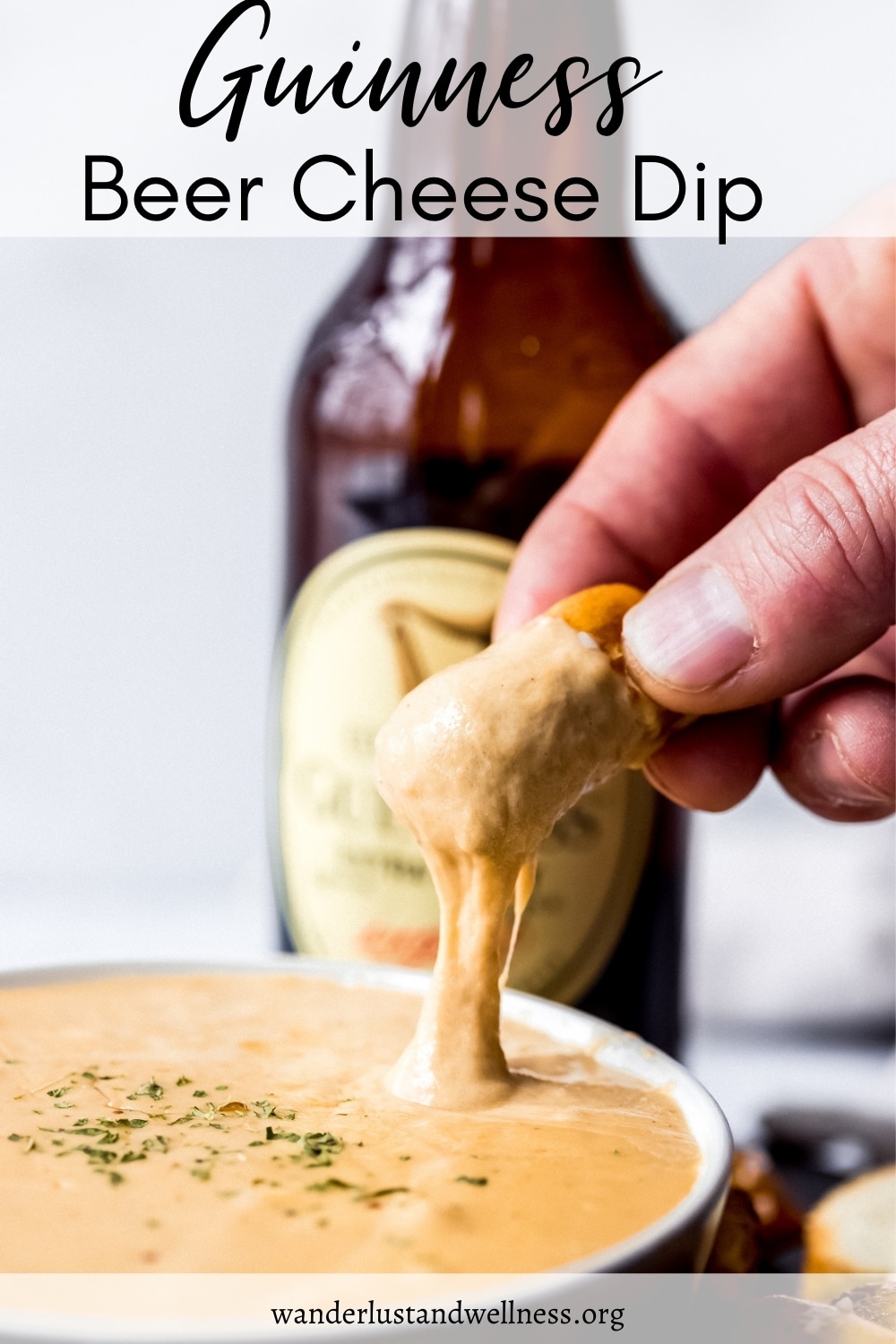 a person dipping pretzels into Guinness beer cheese dip