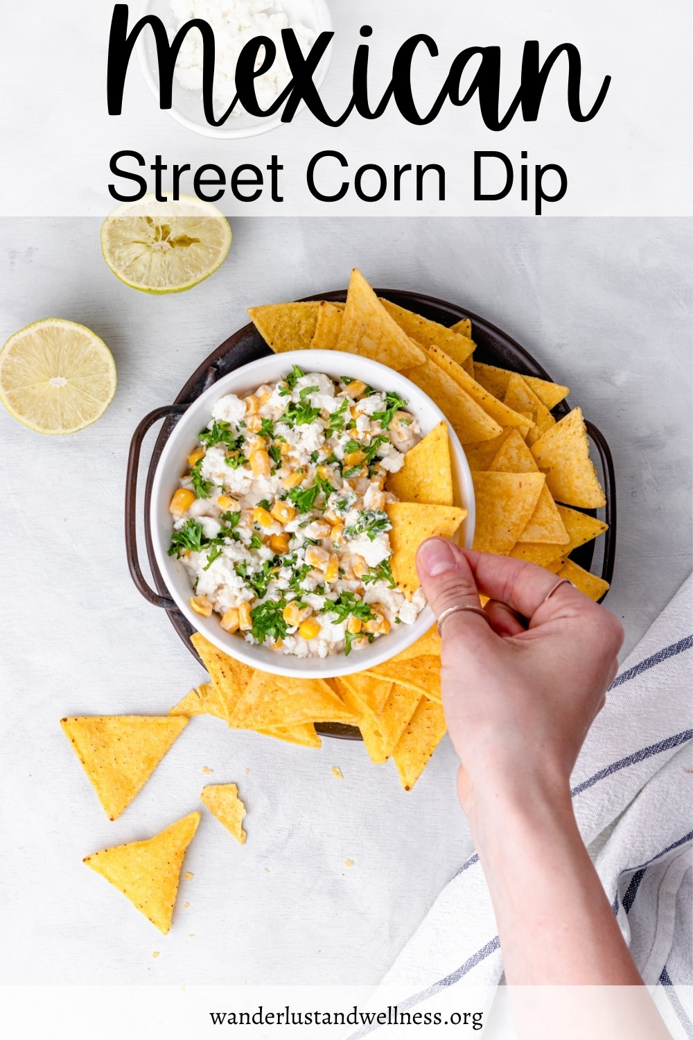 a woman dipping a chip into Mexican street corn dip