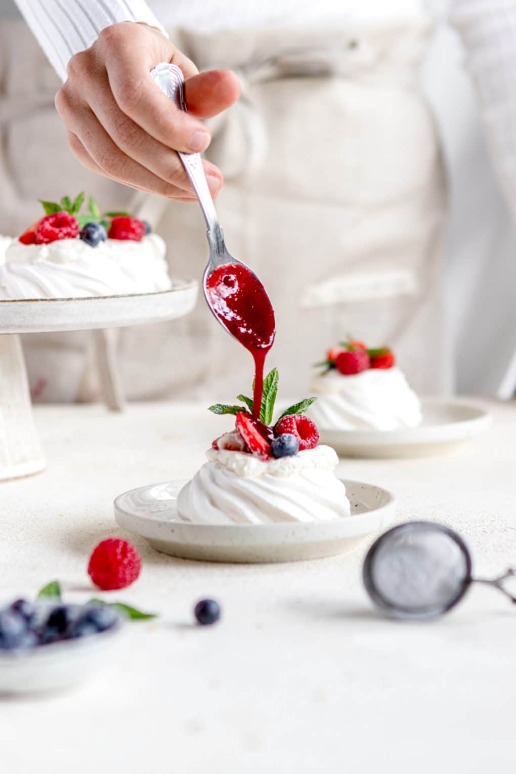drizzling syrup on the Mini Pavlovas