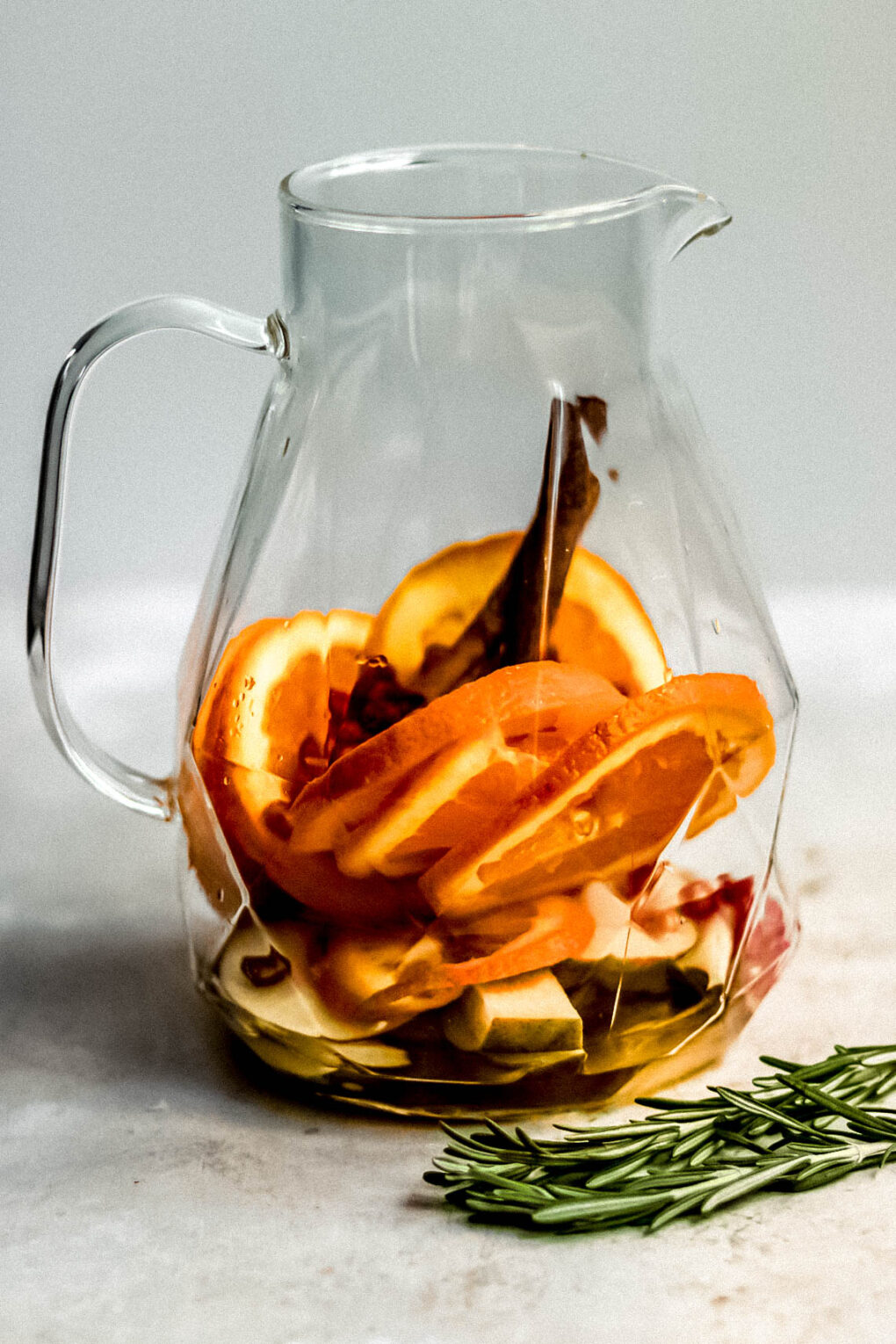 ingredients to make Christmas sangria in a glass pitcher