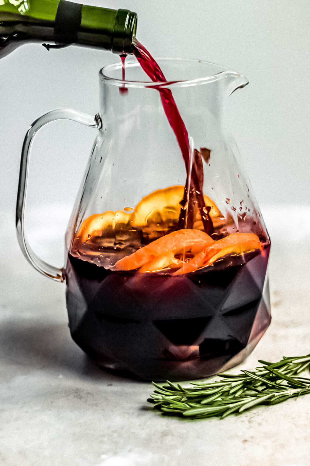 ingredients to make Christmas sangria in a glass pitcher