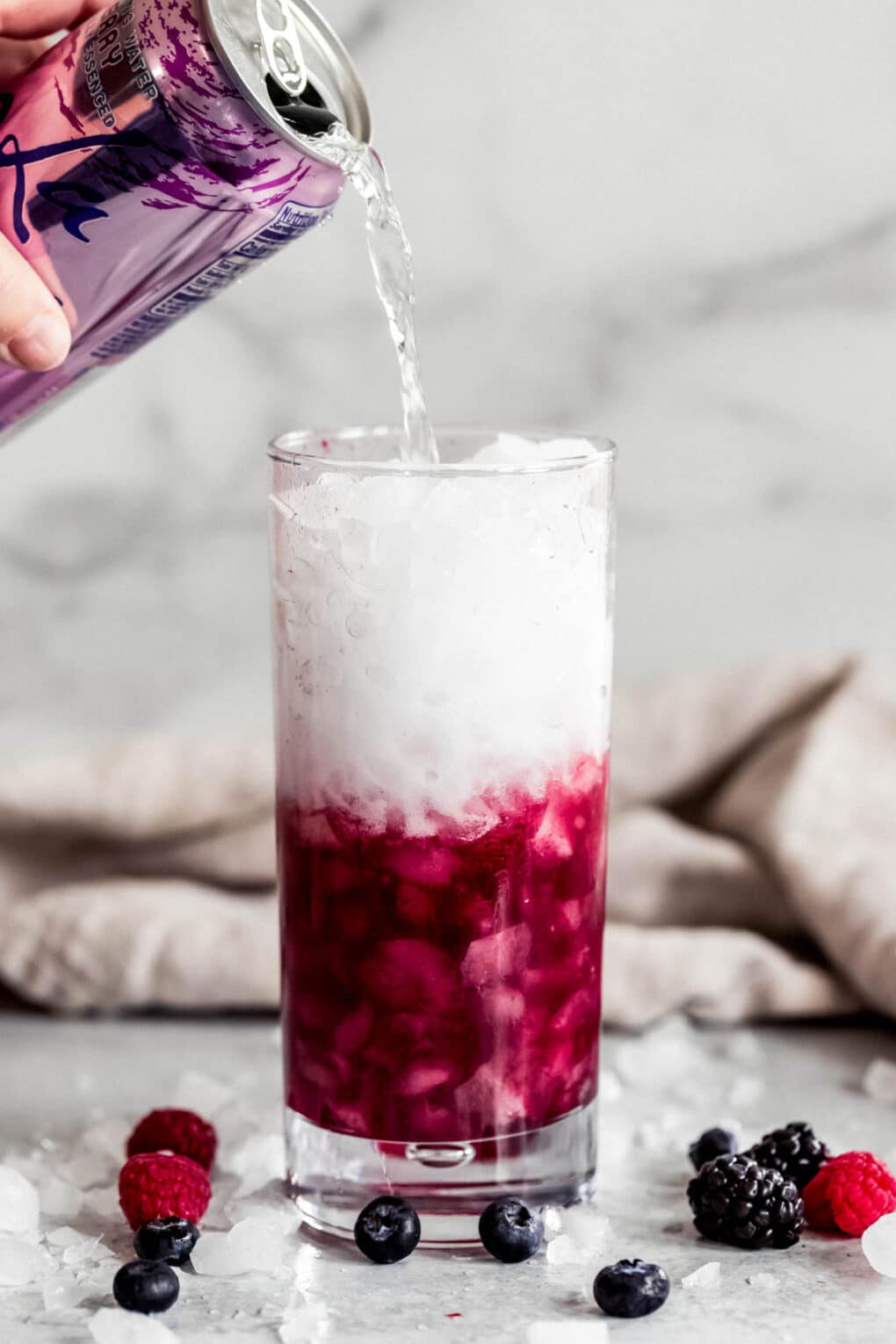 Woman pouring Berry La Croix into cocktail glass