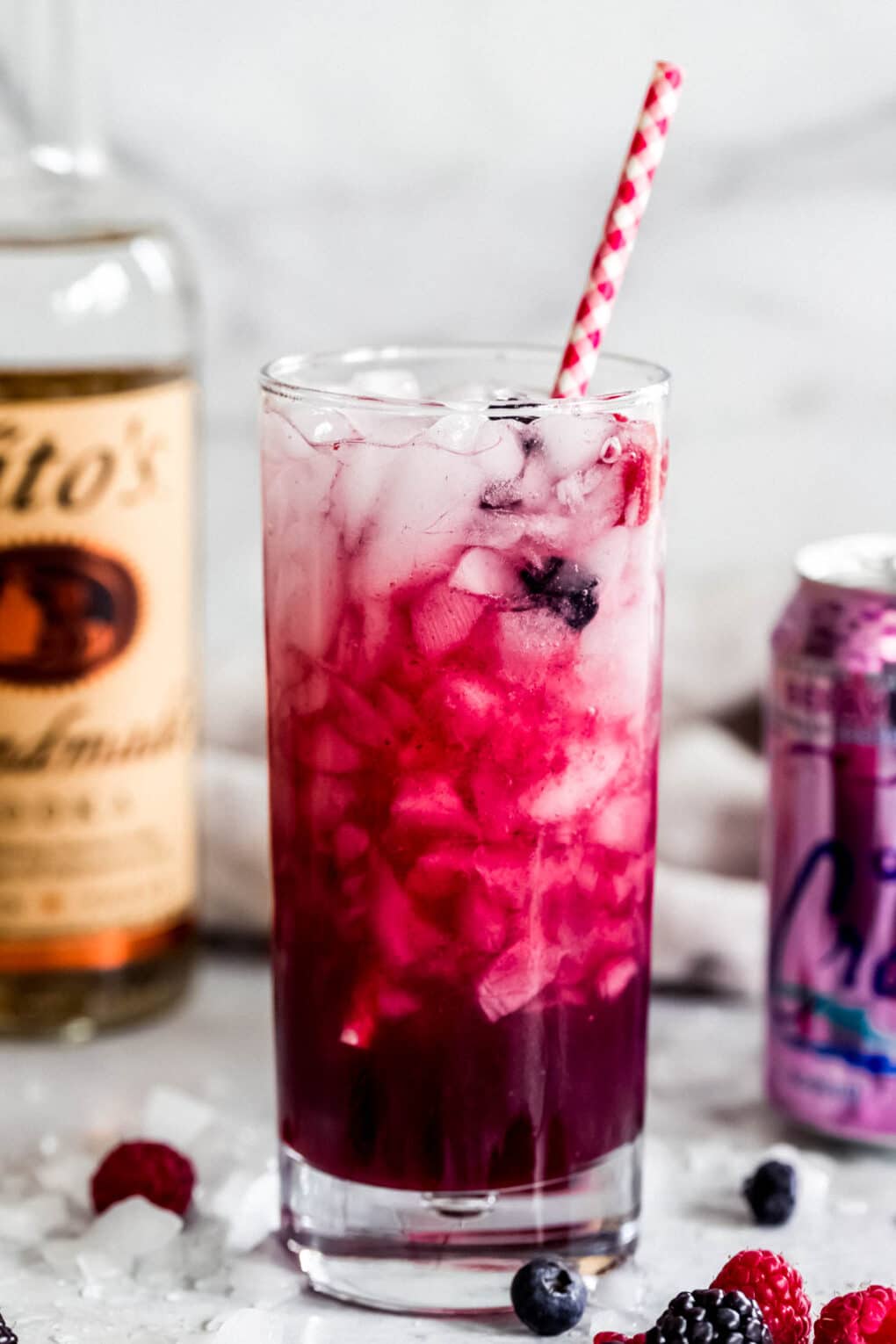 Berry La Croix Vodka Smash with mixed berry garnish and red and white straw