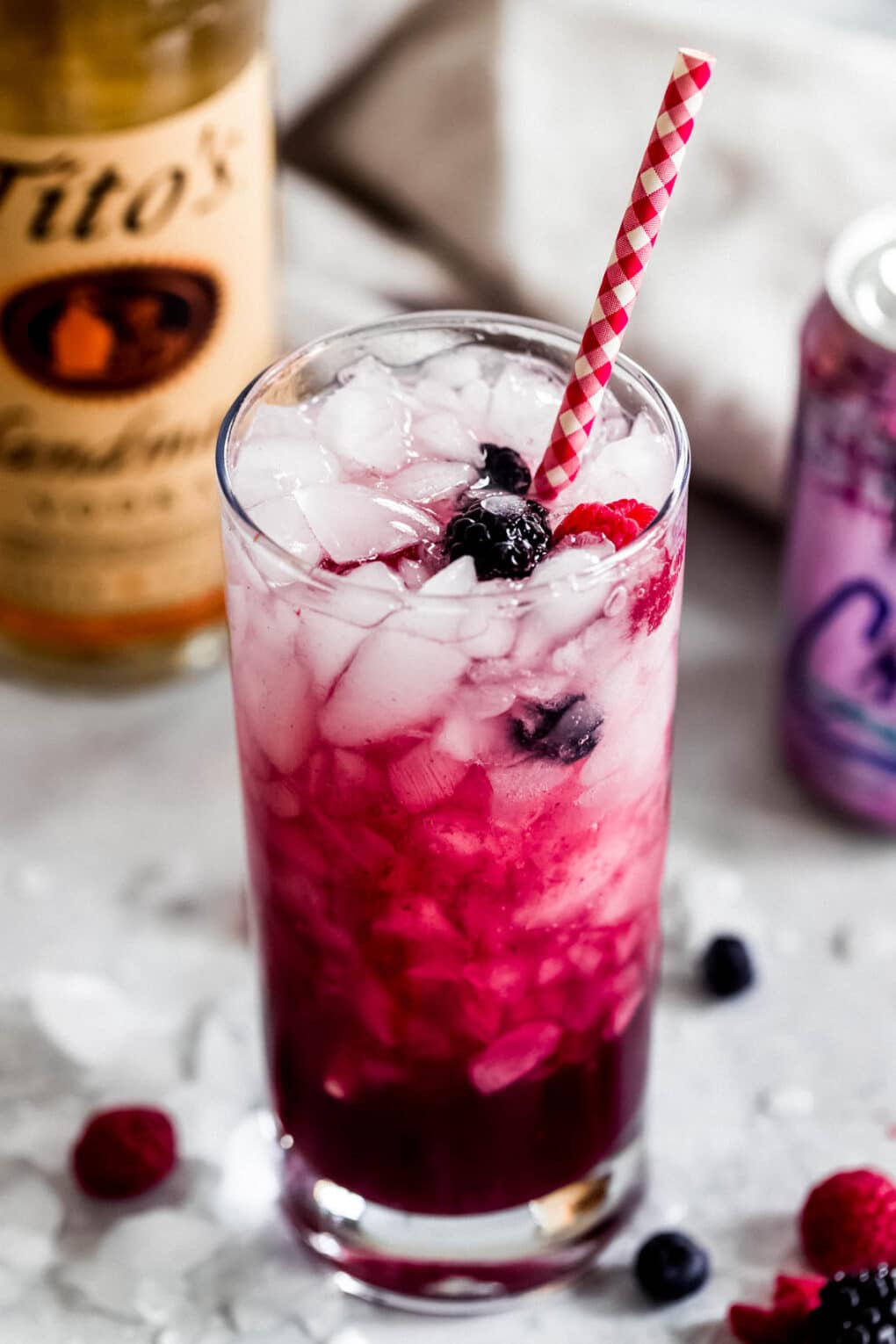 Berry La Croix Vodka Smash with a mixed berry garnish and Red and white straw