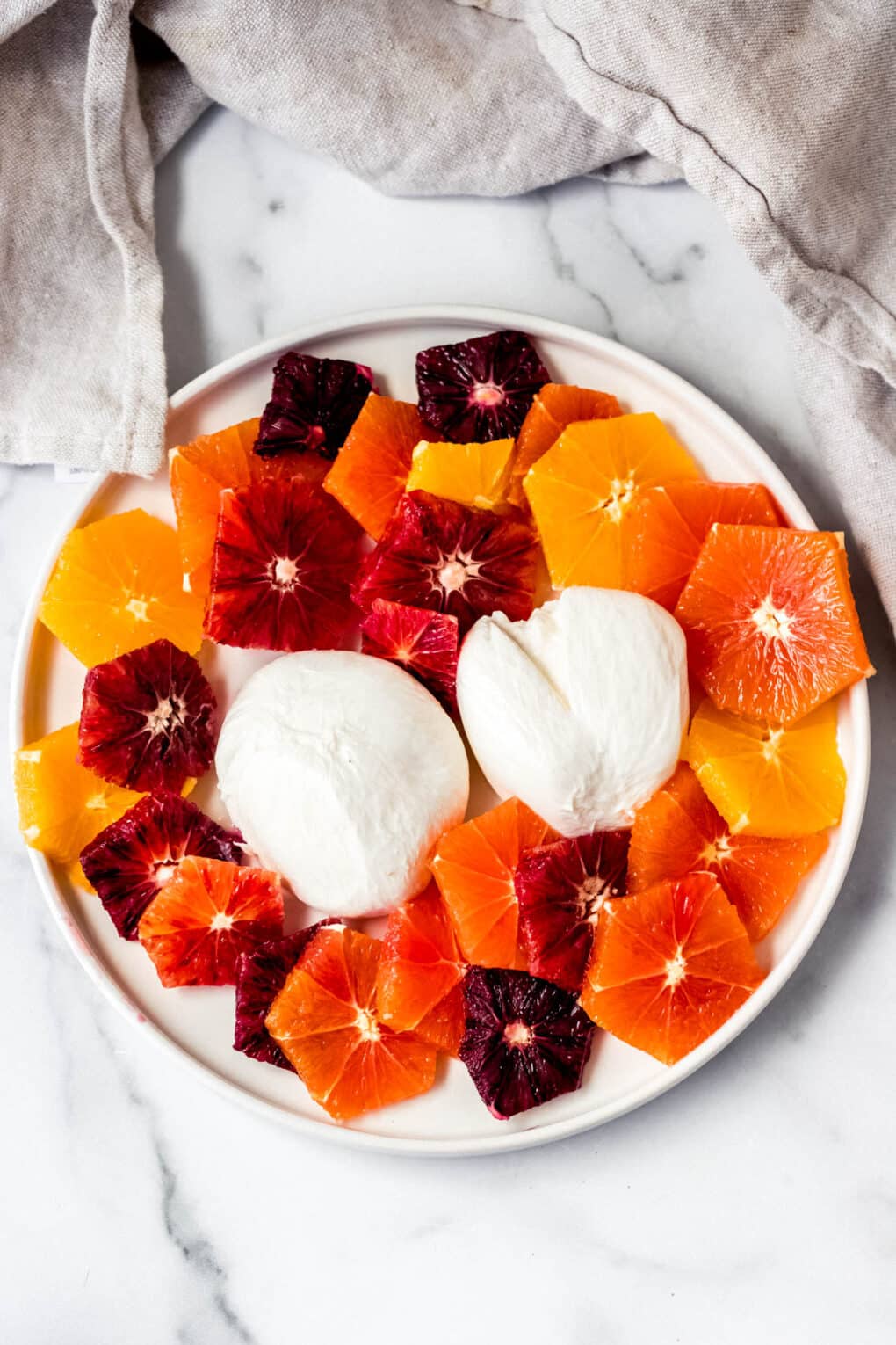 Burrata cheese surrounded by an array of citrus fruits